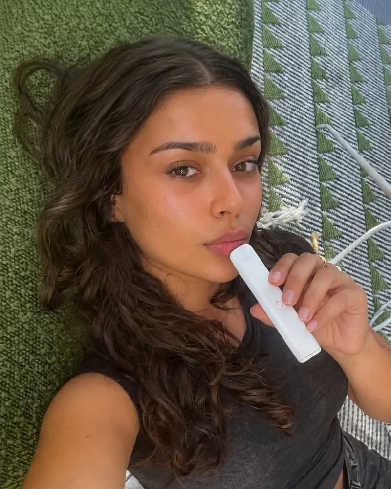 Customer relaxing on a rug with her Pure Peach diffuser